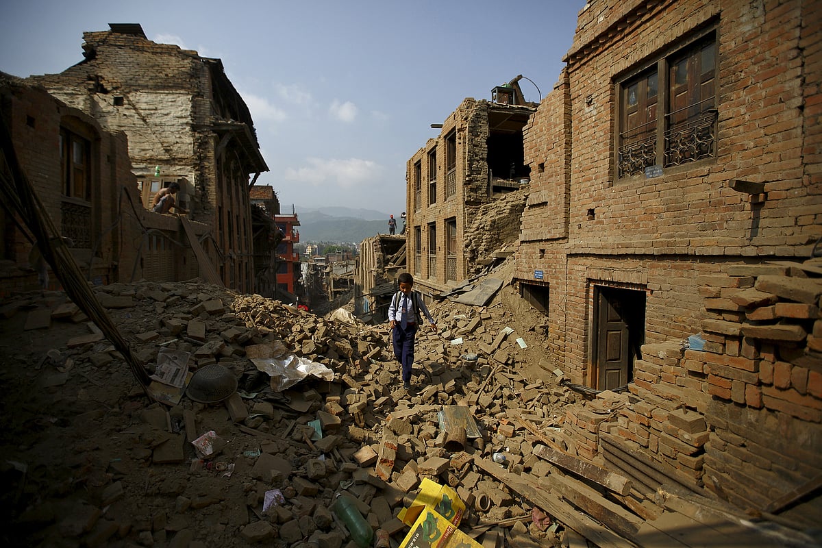 Ten-years-old Niraj Ranjitkar walks along the debris of collapsed houses as he heads towards his school, in Bhaktapur, Nepal May 31, 2015. (REUTERS/Navesh Chitrakar)