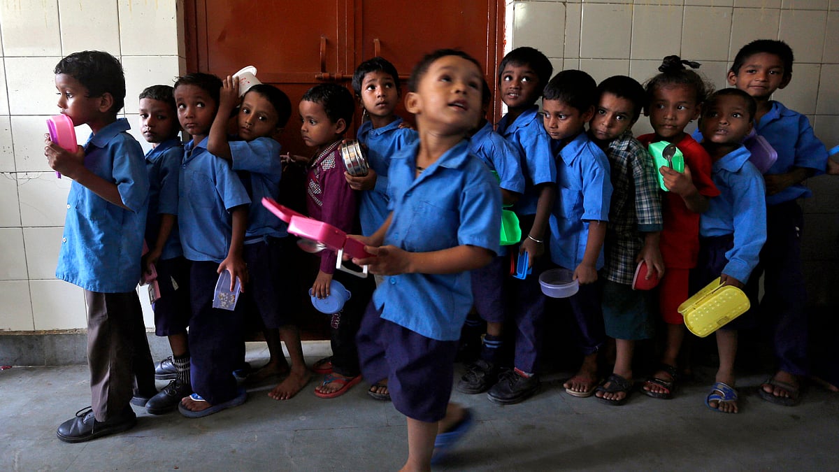 School boys carry their tiffin boxes as they wait to receive the free mid-day meal, distributed by a government-run primary school. (Photo: Reuters)