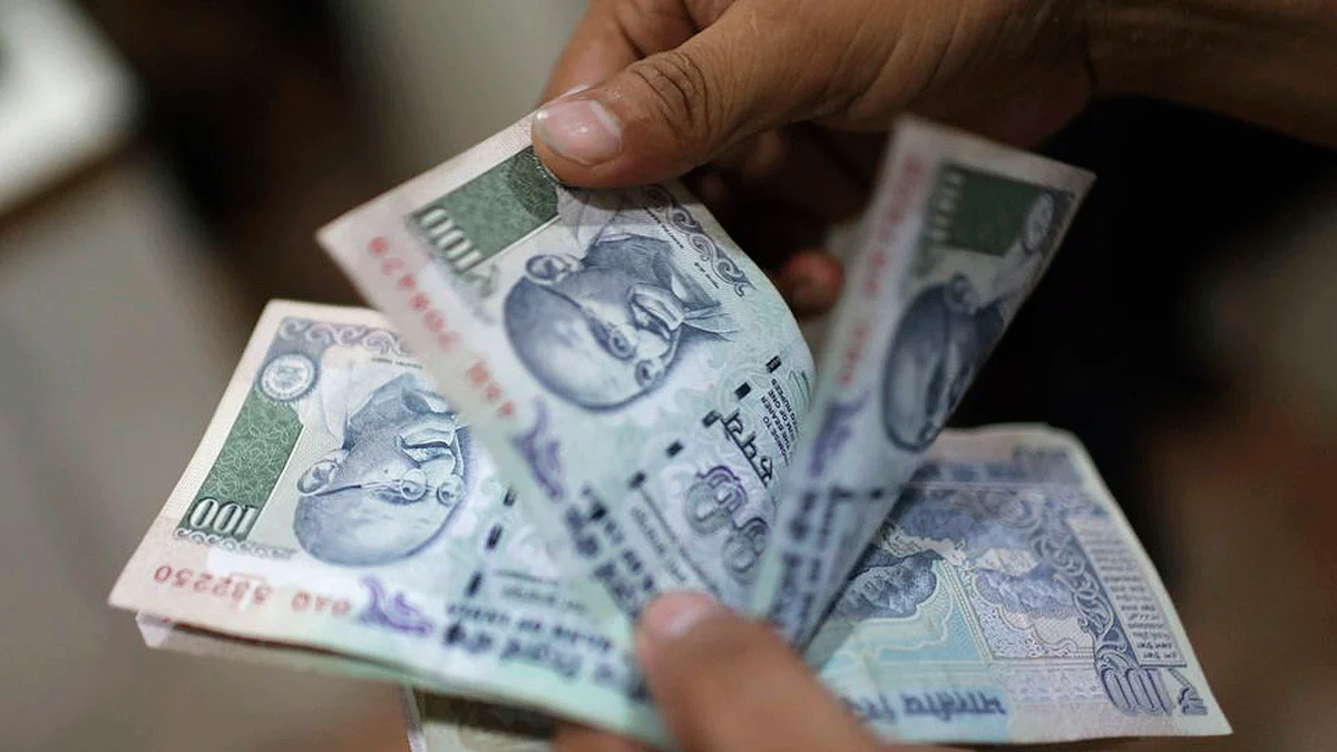  An employee counts rupee currency notes inside a private money exchange office in New Delhi.&nbsp;