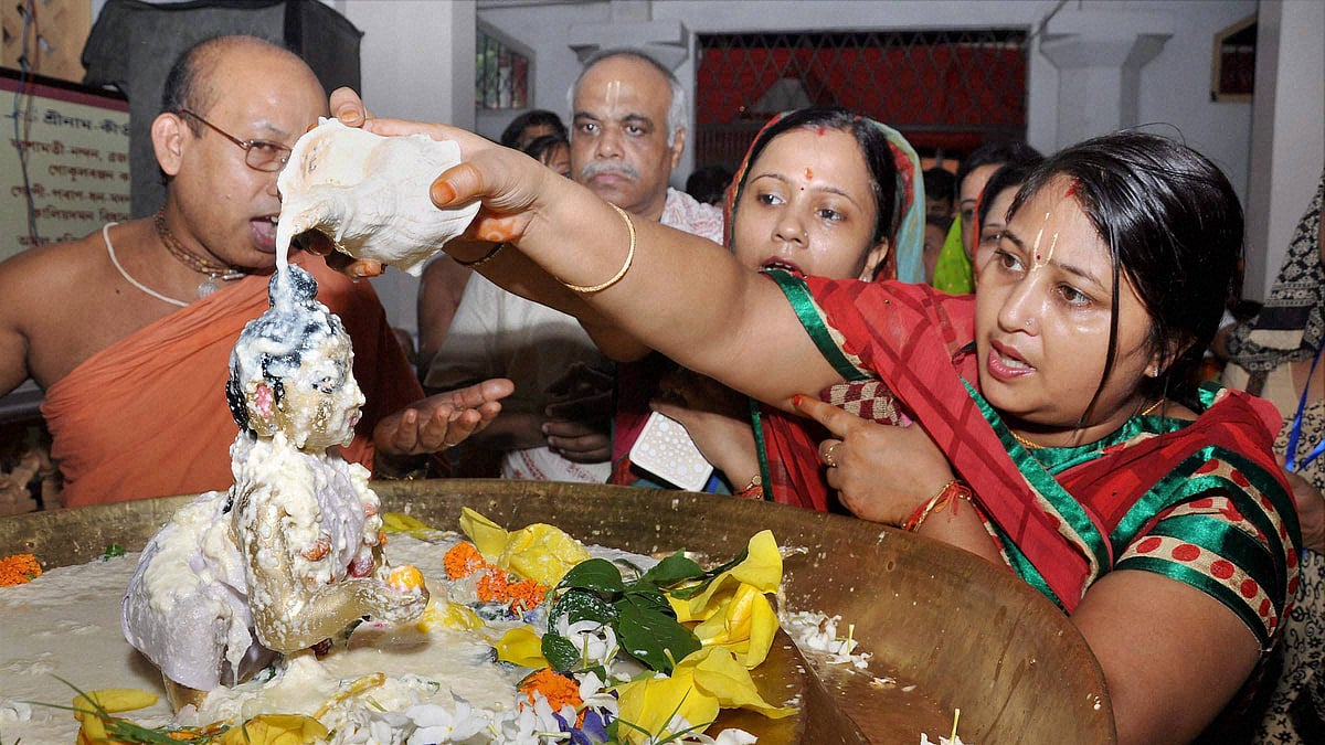 Devotees performing <i>abhishek </i>of Lord Krishna on the occasion of Krishna Janmashtami at ISKCON temple, in Guwahati on Saturday. (Photo: PTI)