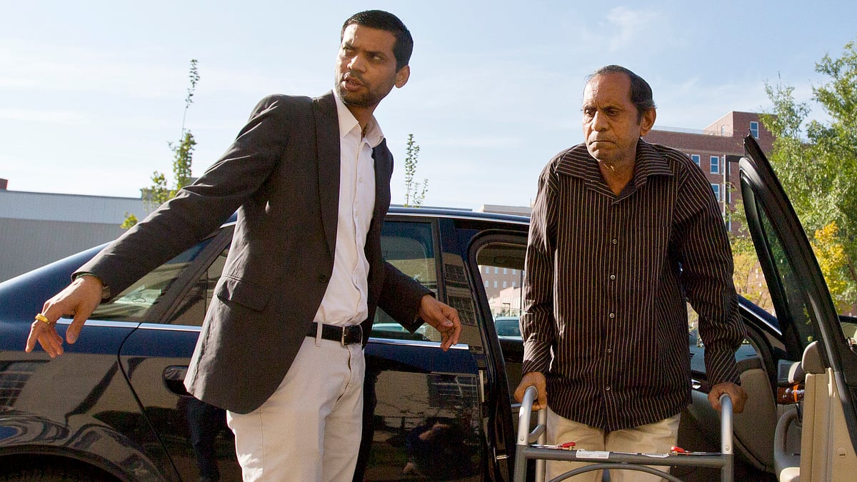 Chirag Patel helps his father, Sureshbhai Patel, out of the car as they arrive outside the federal courthouse. (Photo: AP)