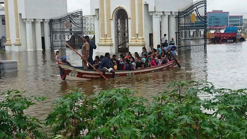 Students of Satyabhama University in Chennai being taken to a building in a boat. (Photo: Sameer Yadav)