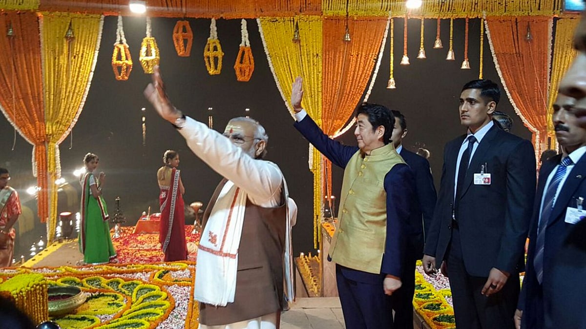Japanese PM Shinzo Abe and PM Modi wave at the crowd gathered for the Ganga aarti at Dasaswamedh Ghat in Varanasi. (Photo: <a href="https://twitter.com/MEAIndia/status/675671356084654080">Twitter.com/@MEAIndia</a>)