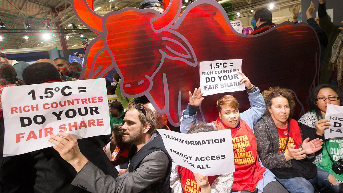 NGO representatives and participants stage a sit-in protest  to denounce the first draft of the COP21 Climate Conference agreement in Le Bourget, north of Paris, France, December 9, 2015. (Photo: AP)