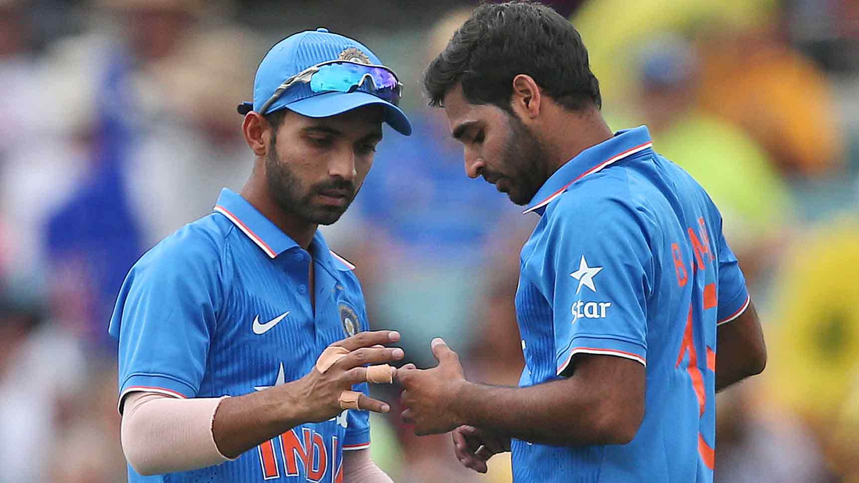 Ajinkya Rahane, left, attends to  Bhuvneshwar Kumar after Kumar hurt his hand while catching a ball during the Canberra ODI. (Photo: AP)