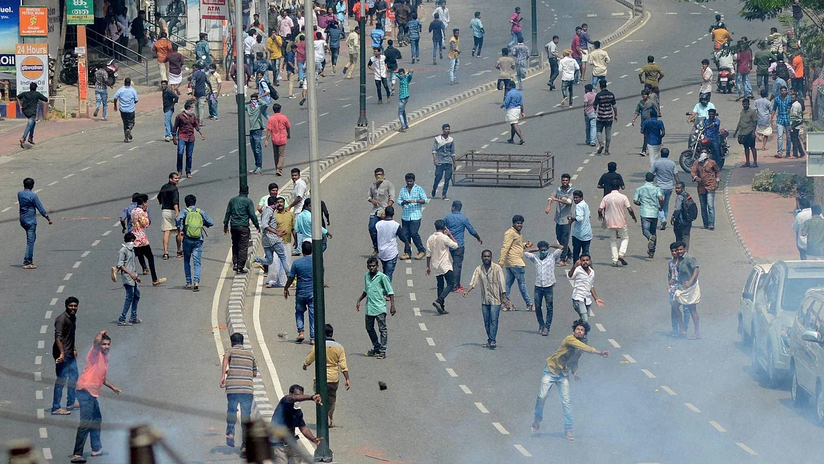 CPI(M) activists pelting stones at the police during clashes at Palayam in Thiruvananthapuram. (Photo: PTI)