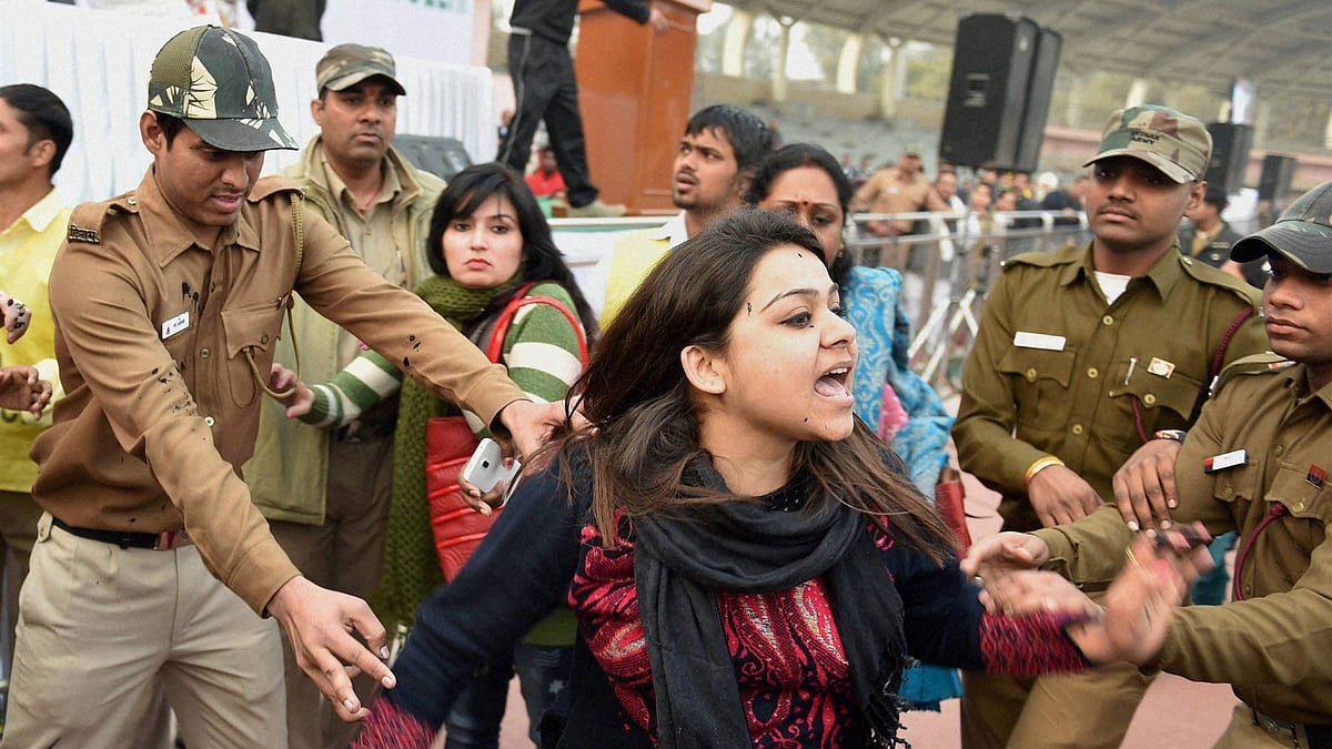 Policemen try to control a member of Aam Aadmi Sena after she splattered Delhi CM Arvind Kejriwal with ink while protesting against the CNG scam, at a “thanksgiving rally following the “success” of his government’s odd-even scheme at Chhatrasal Stadium, in New Delhi on Sunday. (Photo: PTI)