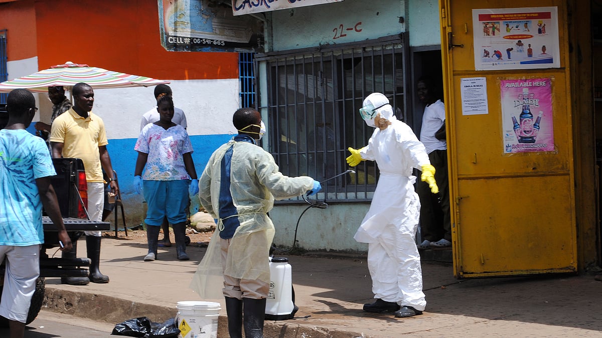 File Photo: Member of a burial team sprays a colleague with chlorine disinfectant in Monrovia, capital of Liberia October 20, 2014. (Photo: Reuters)
