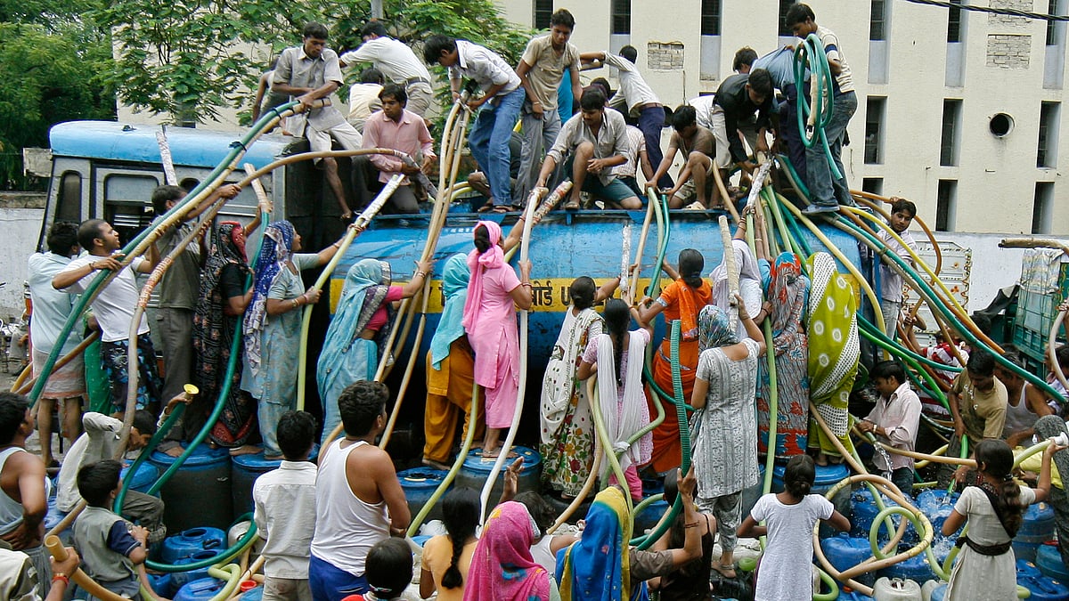 Residents of a Delhi colony crowd around a water tanker provided by Delhi Jal (water) Board to fill their containers. (Photo: Reuters)