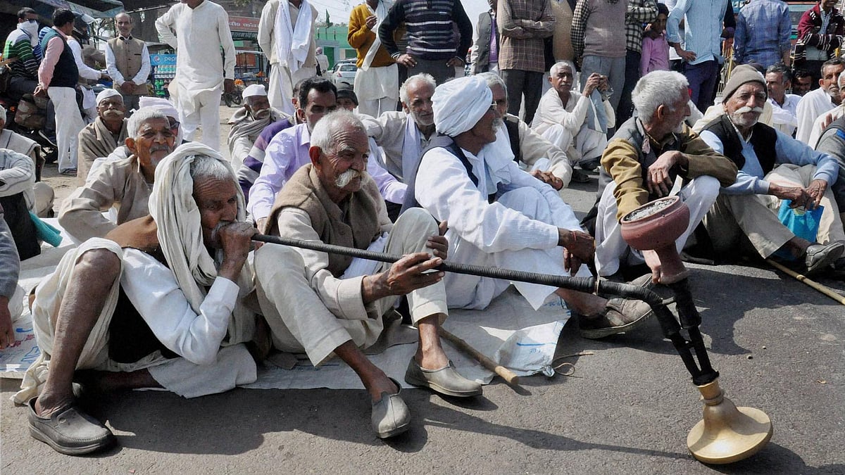 Members of the Jat community, under the banner of Bharatiya Kisan Union, block traffic demanding reservation, in Rajabpur village of Amroha district, Haryana on Sunday. (Photo: PTI)