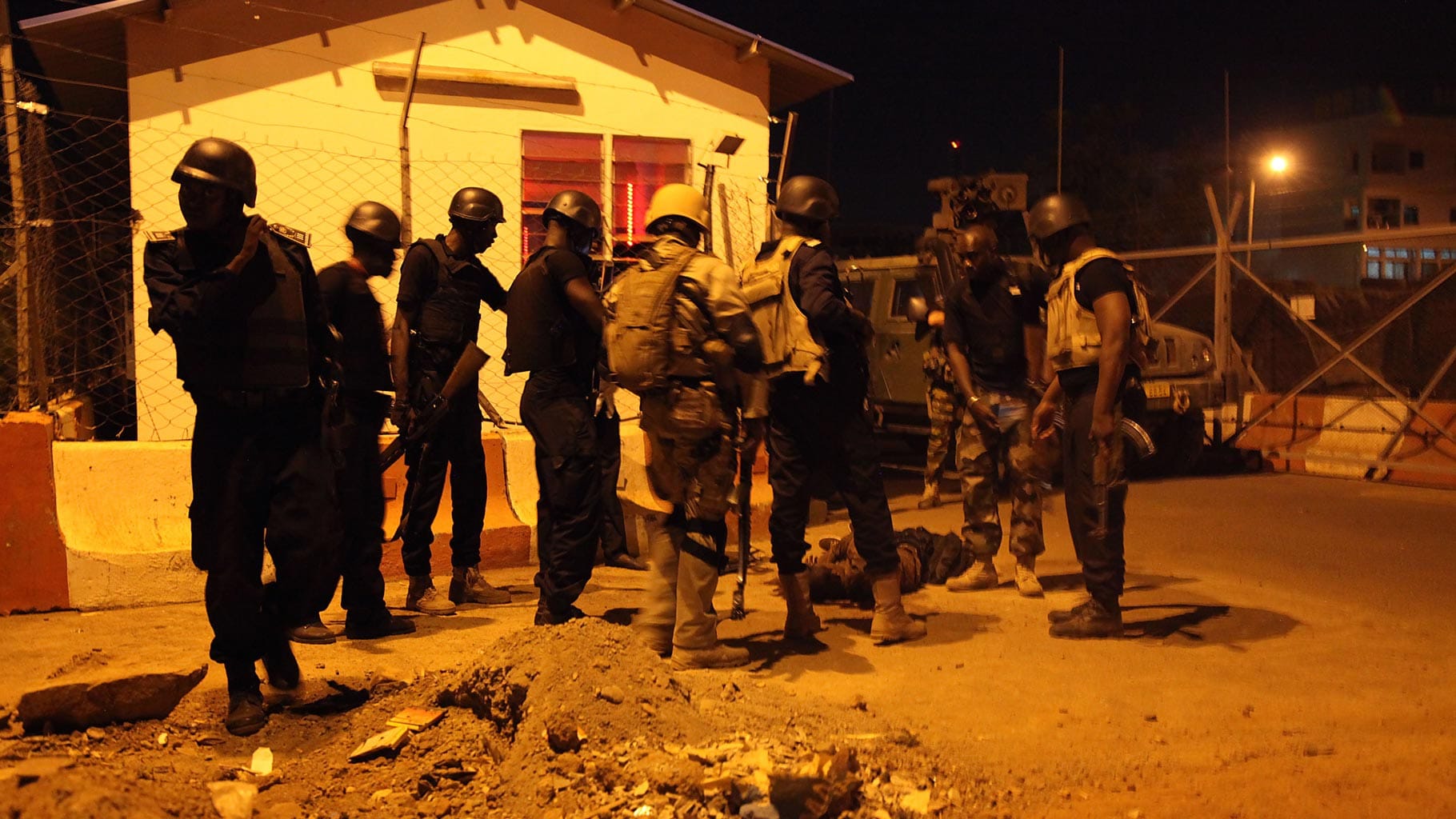 Soldiers stand next to the body of a militant outside the European Union military mission’s entrance in Bamako, Mali, on 21 March 2016. Photo used for representational purpose. (Photo: AP)