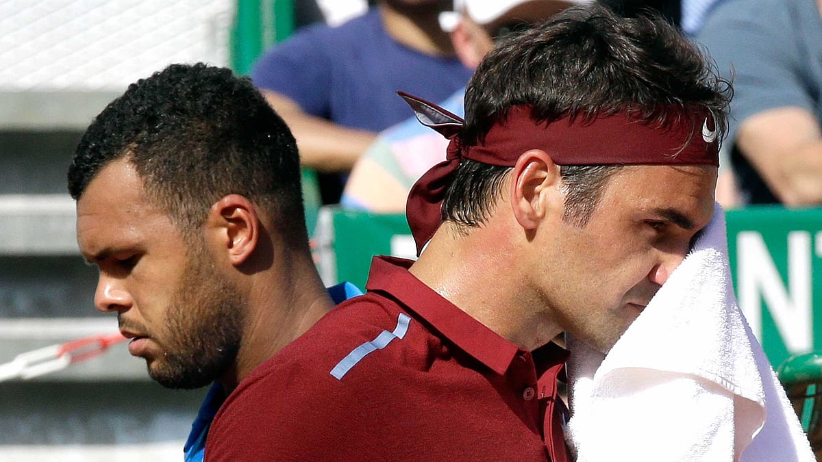 France’s Jo-Wilfried Tsonga, left, crosses Swiss Roger Federer during their quarter final match of the Monte Carlo Tennis Masters tournament (Photo: AP)