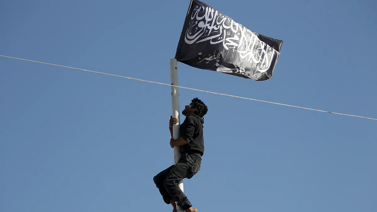 A member of Nusra Front adjusts a Nusra flag at a central square in the northwestern city of Ariha. (Photo: Reuters)