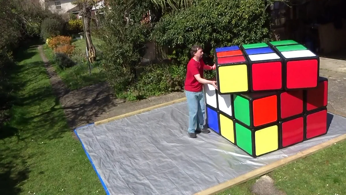 

Tony Fisher running around his massive cube to solve it in his lawns in Ipswich, UK. (Photo: AP/Newsflare screengrab)