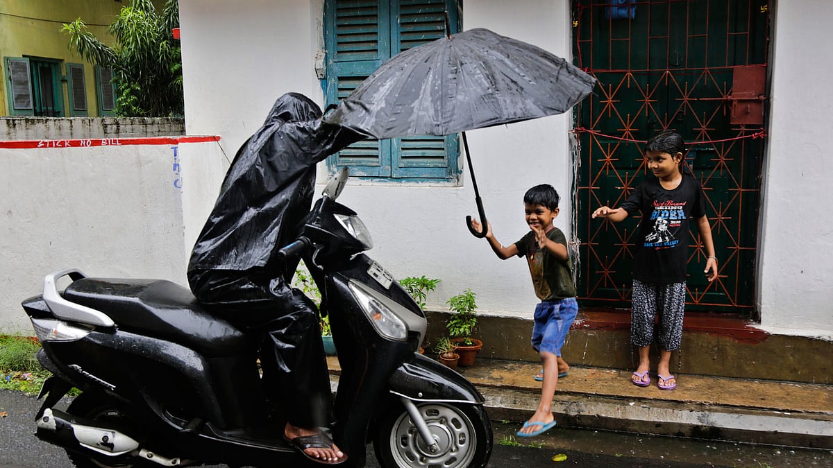 A child reaches to his father for an umbrella as it rains in Kolkata. Image used for representative purposes.<a></a>