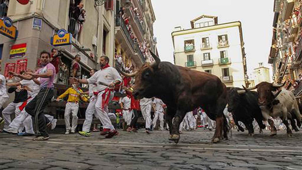 Bulls chasing a crowd in the streets of Pamplona. (Photo: AP)