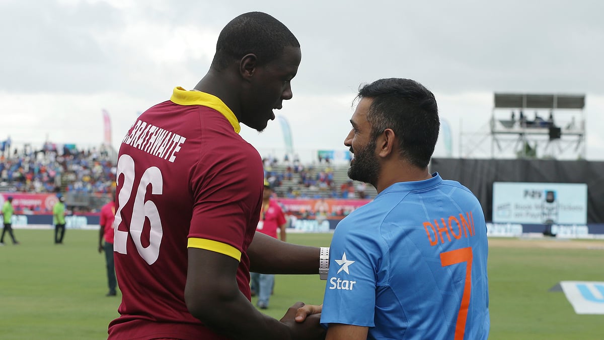  West Indies’ Carlos Brathwaite (26) shakes hands with India’s MS Dhoni (7) after the second Twenty20 international cricket match was called off due to rain. (Photo: AP)