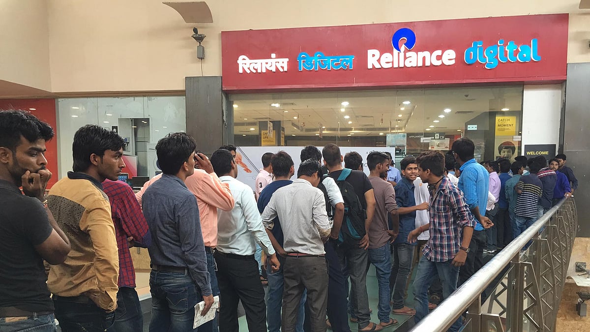 Long queue of customers outside a Reliance store in Noida. (Photo: <b>The Quint</b>)