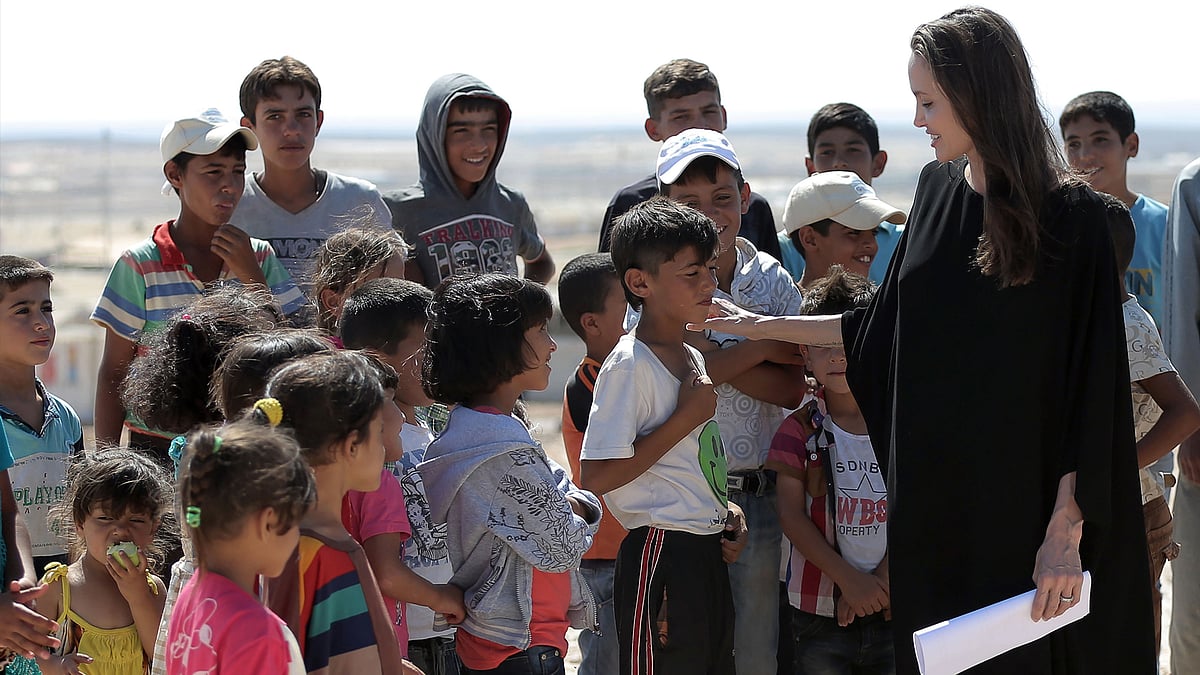 Actress and UN refugee agency envoy special envoy Angelina Jolie talks to a child during a visit to a Syrian refugee camp in Azraq in northern Jordan on Friday. (Photo: AP)