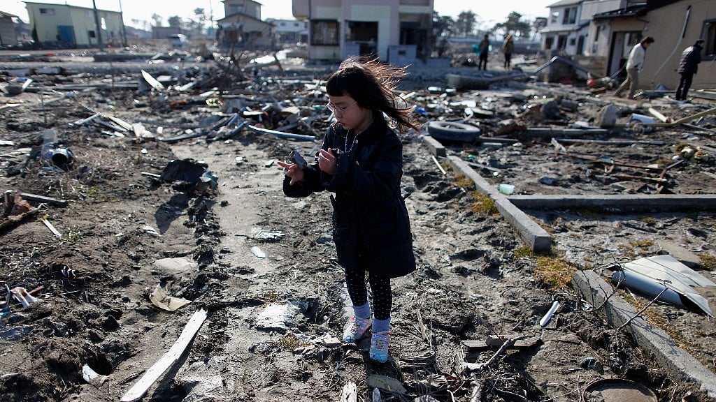 Wakana Kumagai, 7, visits the spot where her house, which was washed away by the 11 March 2011 tsunami, stood. (Photo: Reuters)