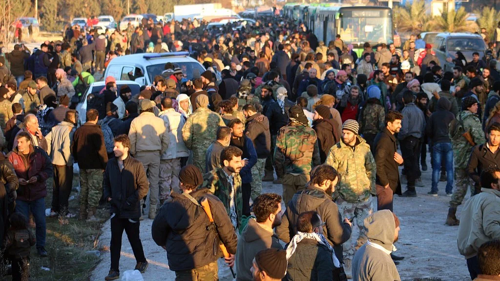 Residents gathered near green government buses for evacuation from eastern Aleppo, Syria. (Photo: AP)