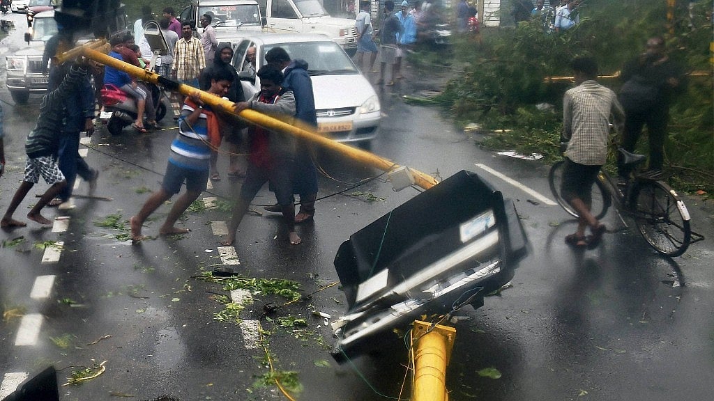 People lifting uprooted poles following a storm in Chennai on Monday. (Photo: PTI) 