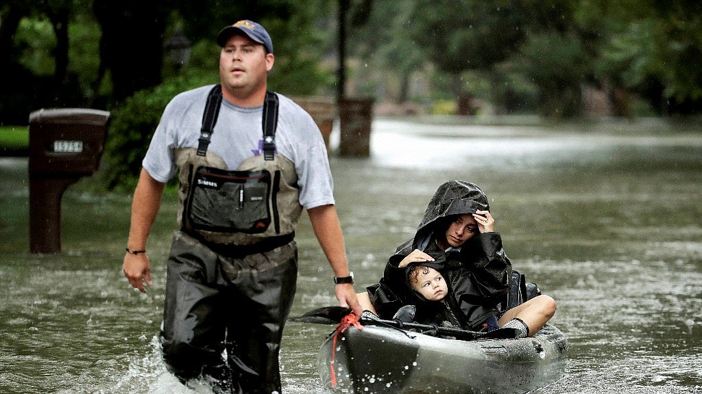 People evacuate a neighborhood inundated by floodwaters from Tropical Storm Harvey in Houston, Texas.