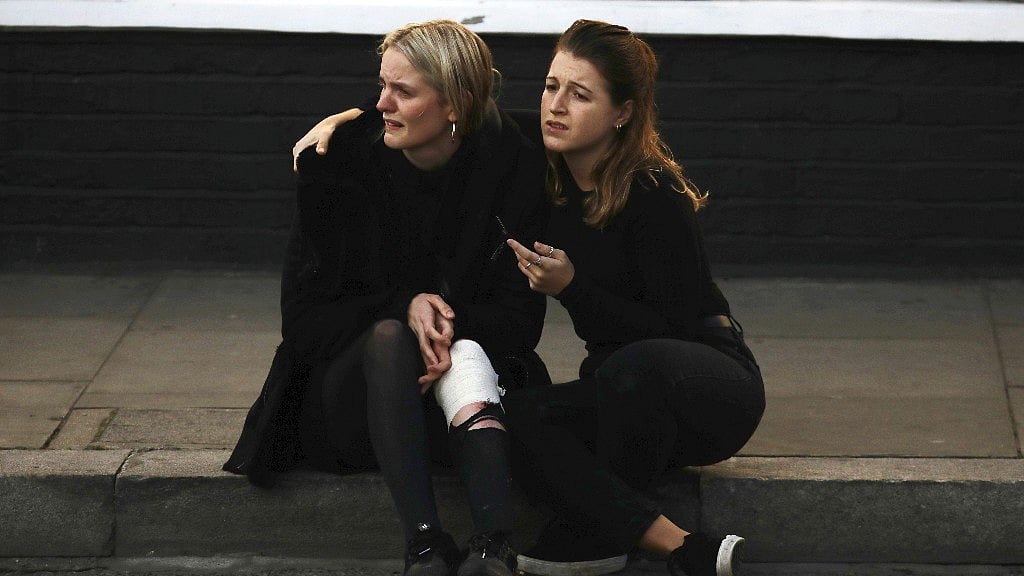 An injured woman reacts outside Parsons Green tube station in London.