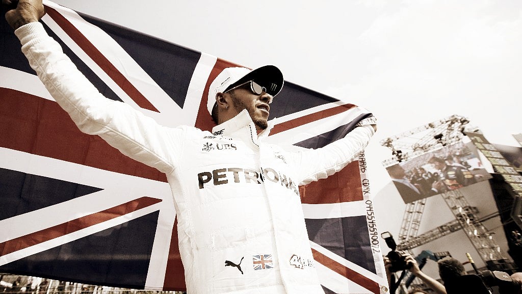 British driver Lewis Hamilton holds up a British flag as he celebrates wining his fourth Formula One championship after the Mexican Grand Prix auto race at the Hermanos Rodriguez racetrack in Mexico City