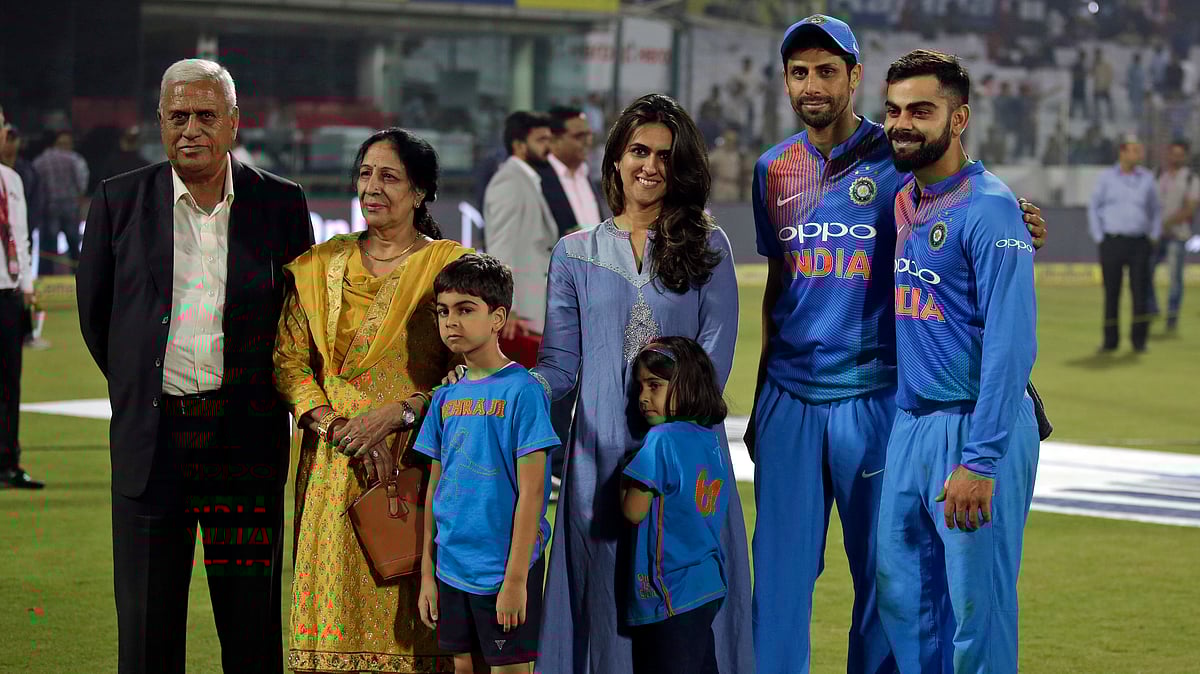India’s Ashish Nehra, second right, pose with his family, to his left and captain Virat Kohli, right, as he bids farewell at the end of his last international match, during their first Twenty20 cricket match against New Zealand in New Delhi