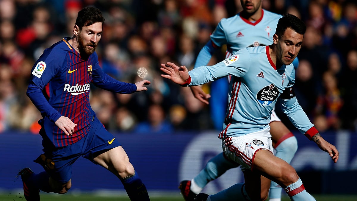 FC Barcelona’s Lionel Messi, left, duels for the ball against Celta Vigo’s Nemanja Radoja.
