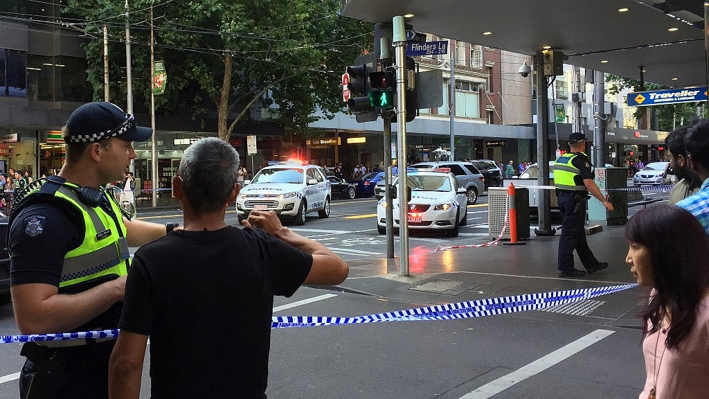 <p>Police officers stand guard after the arrest of the driver who mowed down pedestrians on Flinders Street in Melbourne.&nbsp;</p>