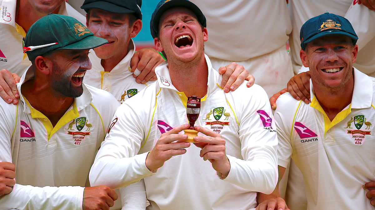 Australia’s captain Steve Smith shares a laugh as he holds a replica of the Ashes urn next to his teammates.