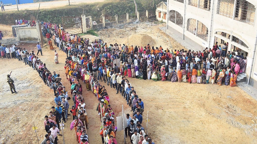 People wait in a queues to cast their votes for the Tripura Assembly Election in Agartala on 18 February.