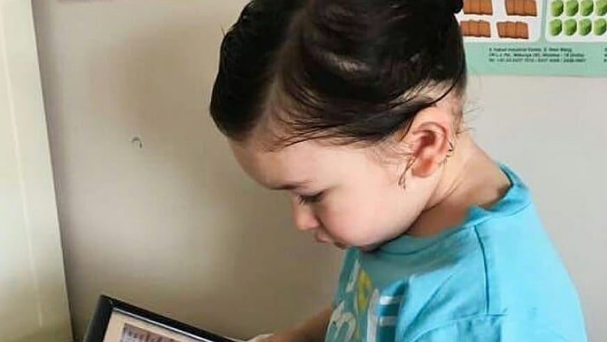 Taimur Ali Khan stares into a picture of his dad, Saif Ali Khan.