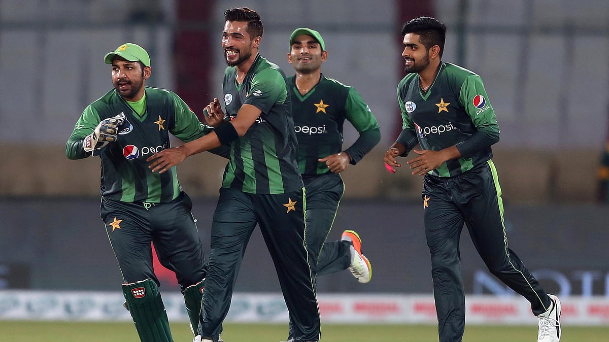 Pakistani pacer Mohammad Amir (centre) celebrates with teammates after taking the wicket of West Indies batsman Andre Fletcher during the 1st T20  match at National stadium in Karachi.