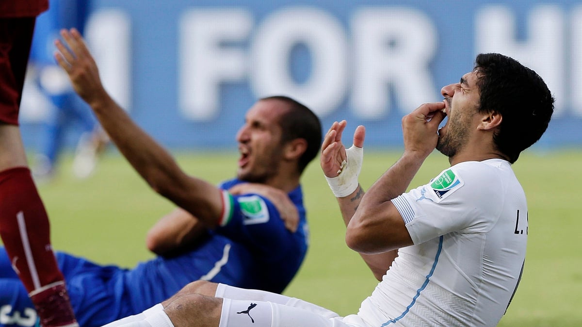 In this June 24, 2014 file photo, Uruguay’s Luis Suarez holds his teeth after biting Italy’s Giorgio Chiellini’s shoulder during the group D World Cup soccer match between Italy and Uruguay at the Arena das Dunas in Natal, Brazil. 