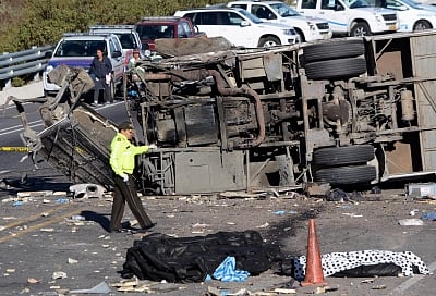 QUITO, Aug. 14, 2018 (Xinhua) -- A policeman walks past the debris of a bus at the site of a traffic accident on the Pifo-Papallacta Highway, east of Quito, capital of Ecuador, on Aug. 14, 2018. At least 24 people were killed and 19 others injured when a long-distance bus crashed with a smaller vehicle on a highway and overturned near Ecuador