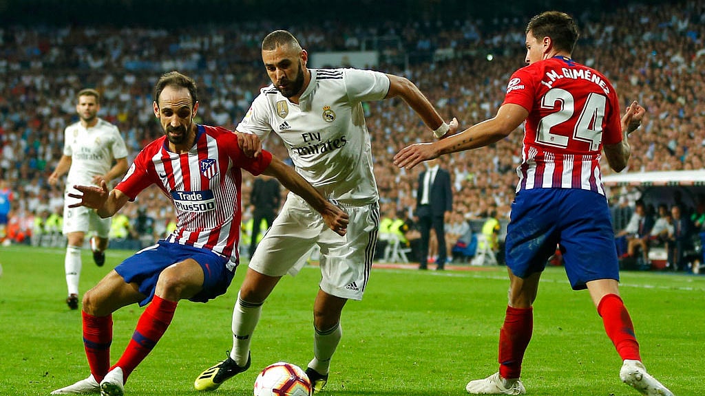 Real Madrid’s Karim Benzema, centre, vies for the ball with Atletico Madrid’s Juanfran, left, and Jose Maria Gimenez.