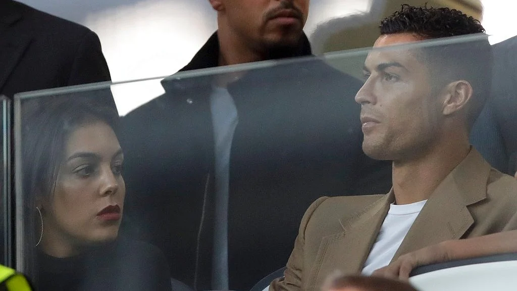 Juventus forward Cristiano Ronaldo and his partner Georgina sit in the stands prior to the Champions League match between Juventus and Young Boys at the Allianz stadium in Turin on October 2, 2018. 