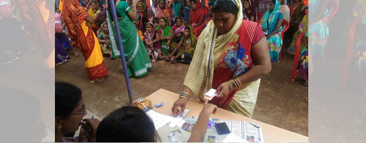 A beneficiary of the Sanchaar Kranti Yojana receives a token from a government official before she heads in to collect her smartphone in Ringni village in Chhattisgarh’s Durg district at a phone distribution event on 6 September 2018.&nbsp;