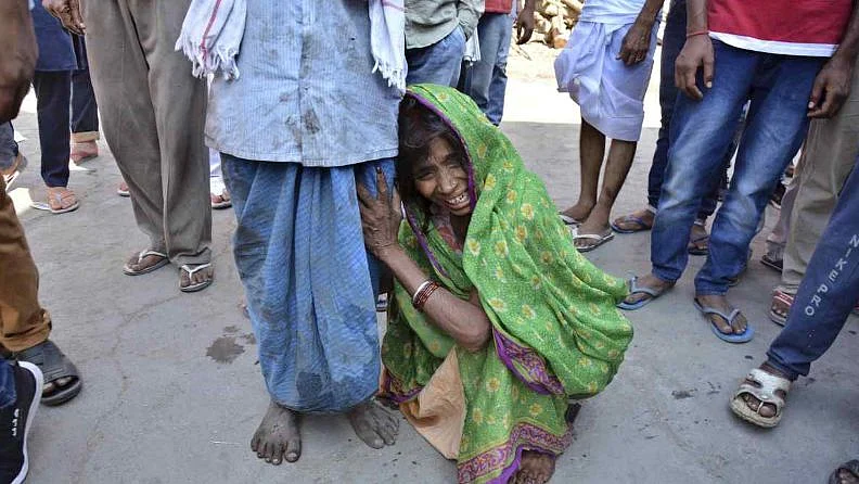 A woman cries holding on to her husband during the cremation of her son who was killed in the train accident.