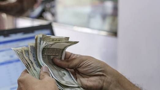 A cashier counts Indian rupee banknotes in the Byculla area of Mumbai, India.  &nbsp;