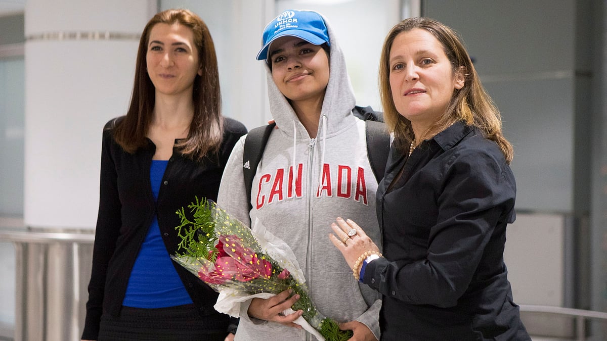 Rahaf Mohammed Alqunun, 18, center, stands with Canadian Minister of Foreign Affairs Chrystia Freeland, right, as she arrives at Toronto Pearson International Airport, on Saturday, 12 January, 2019.