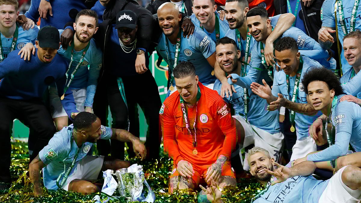 Manchester City players celebrate after winning the EFL Cup by defeating Chelsea on penalties in the final at Wembley.