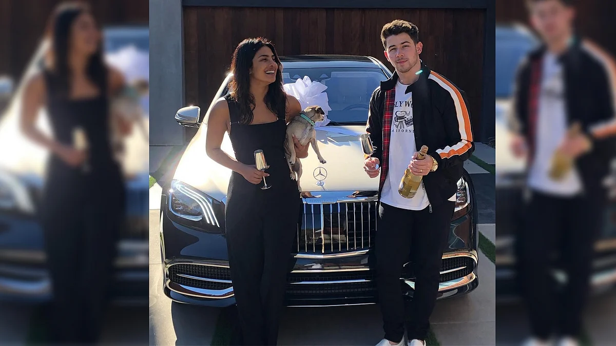 Priyanka Chopra and Nick Jonas posing with their new car.&nbsp;