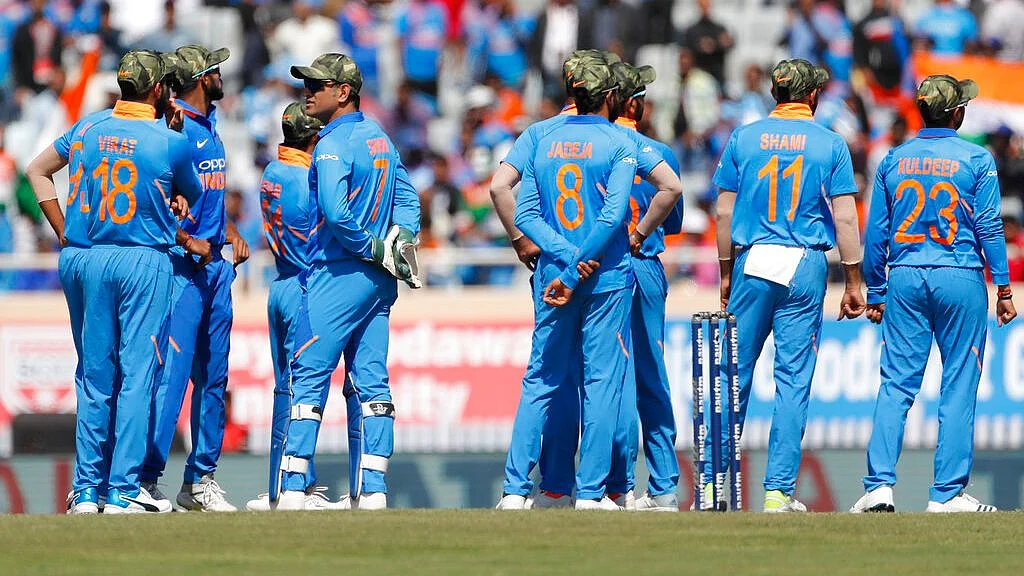 Indian players sport camouflage caps as they wait for a decision from the  umpire during the third one day international cricket match between India and Australia in Ranchi on 8 March 2019.&nbsp;