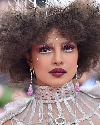 Actress Priyanka Chopra Jonas at the Met Gala 2019 in New York. For the event, the actress went bold and played up the theme with a zany look in a silver gown with colourful ruffled feathers, a very high leg split, a matching cape along with her big hairstyle that included a crown on top.