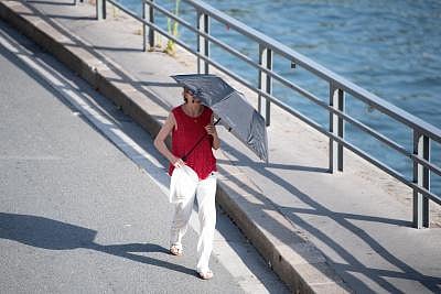 PARIS, June 28, 2019 (Xinhua) -- A woman walks with a sunshade in Paris, France, June 27, 2019. The national weather center, Meteo France, on Thursday warned of "exceptional heat peak" on June 28, placing 4 southern regions on red alert, the highest alert on the agency