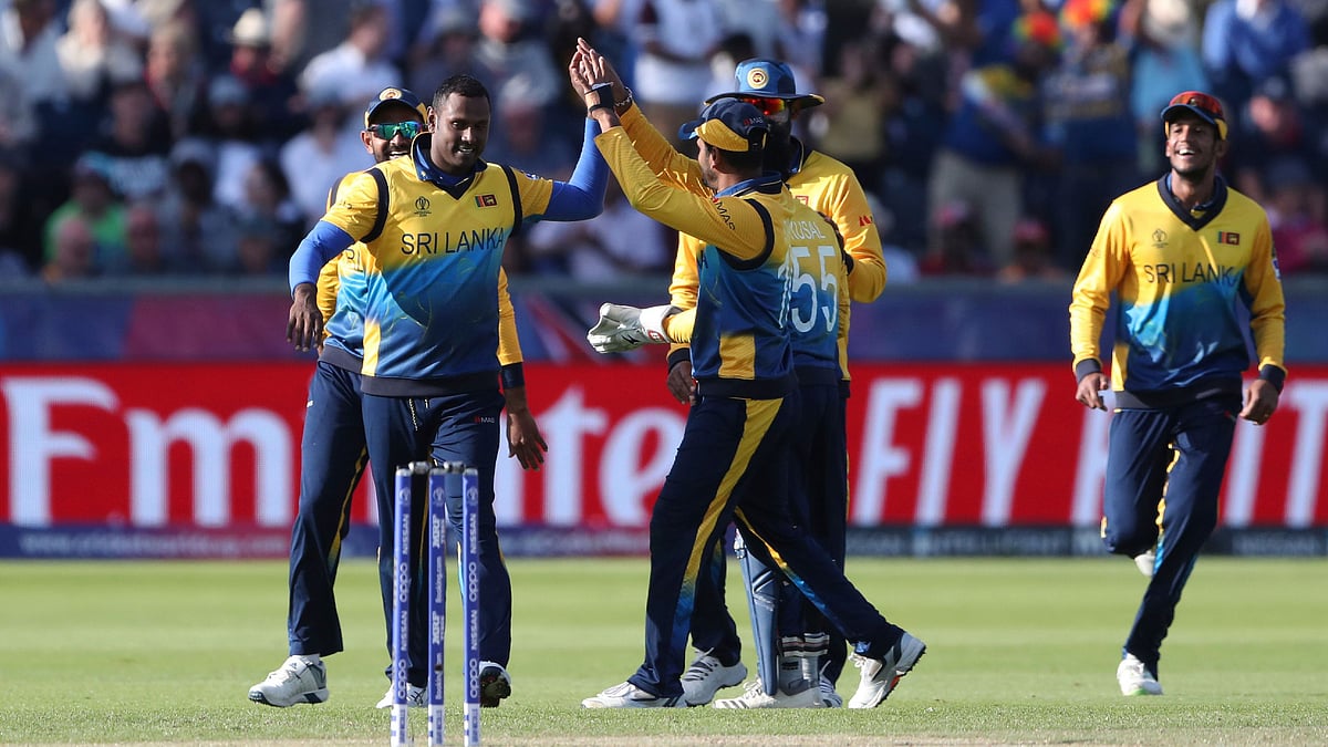 Sri Lanka’s bowler Angelo Mathews, left, celebrates with teammates after dismissing West Indies’ batsman Nicholas Pooran for 118 runs.